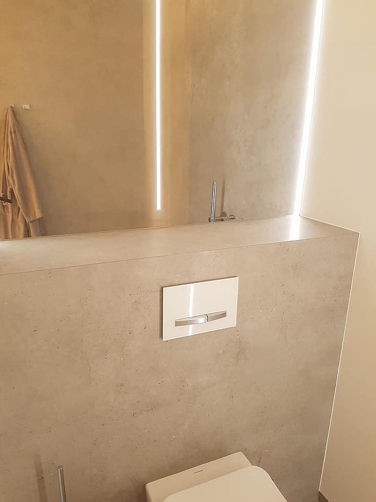 Minimalistisches WC-Design mit indirekter LED-Beleuchtung, die ein goldenes Lichtszenario schafft.