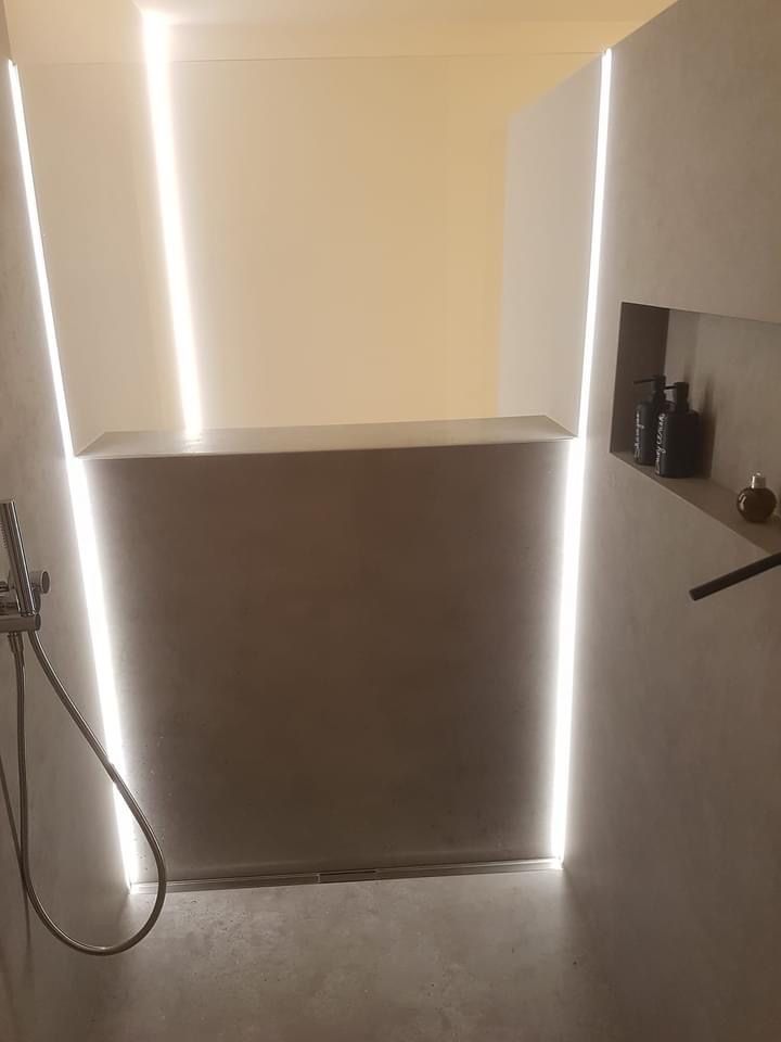 Walk-In-Dusche mit schmalen LED-Lichtstreifen.