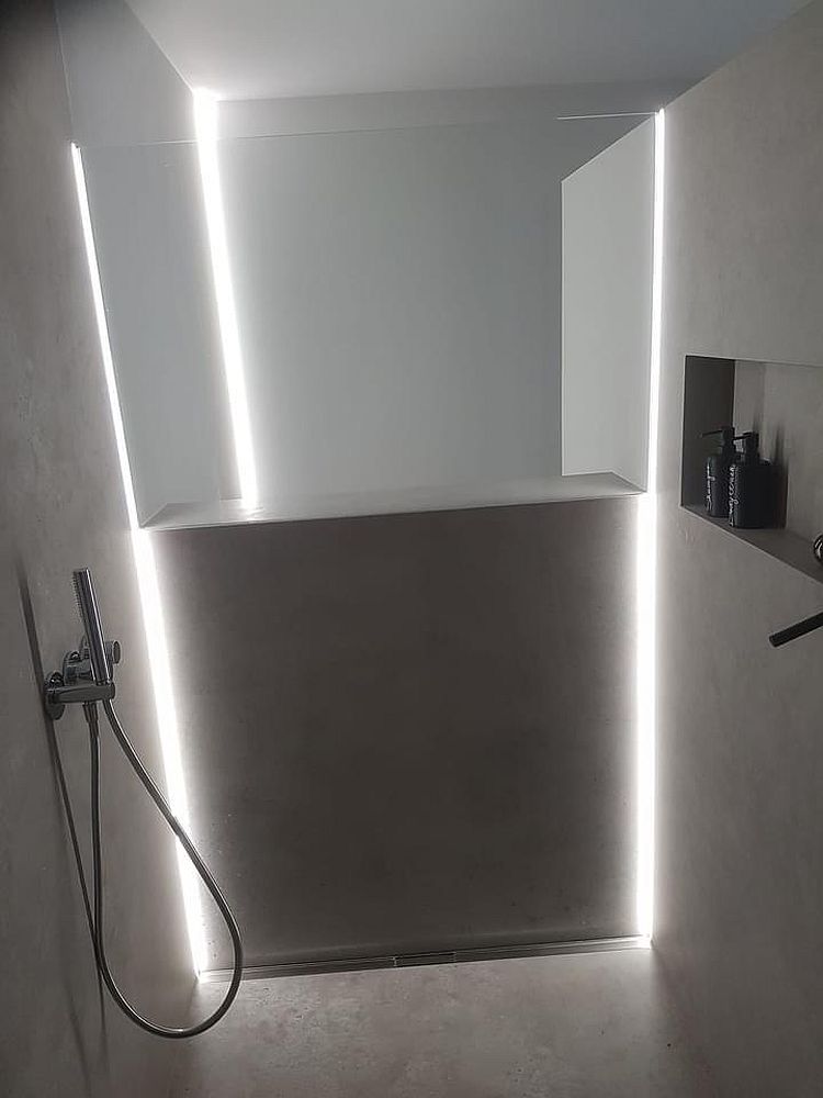 Moderne Walk-In-Dusche mit silberner Beleuchtung durch vertikale LED-Streifen.