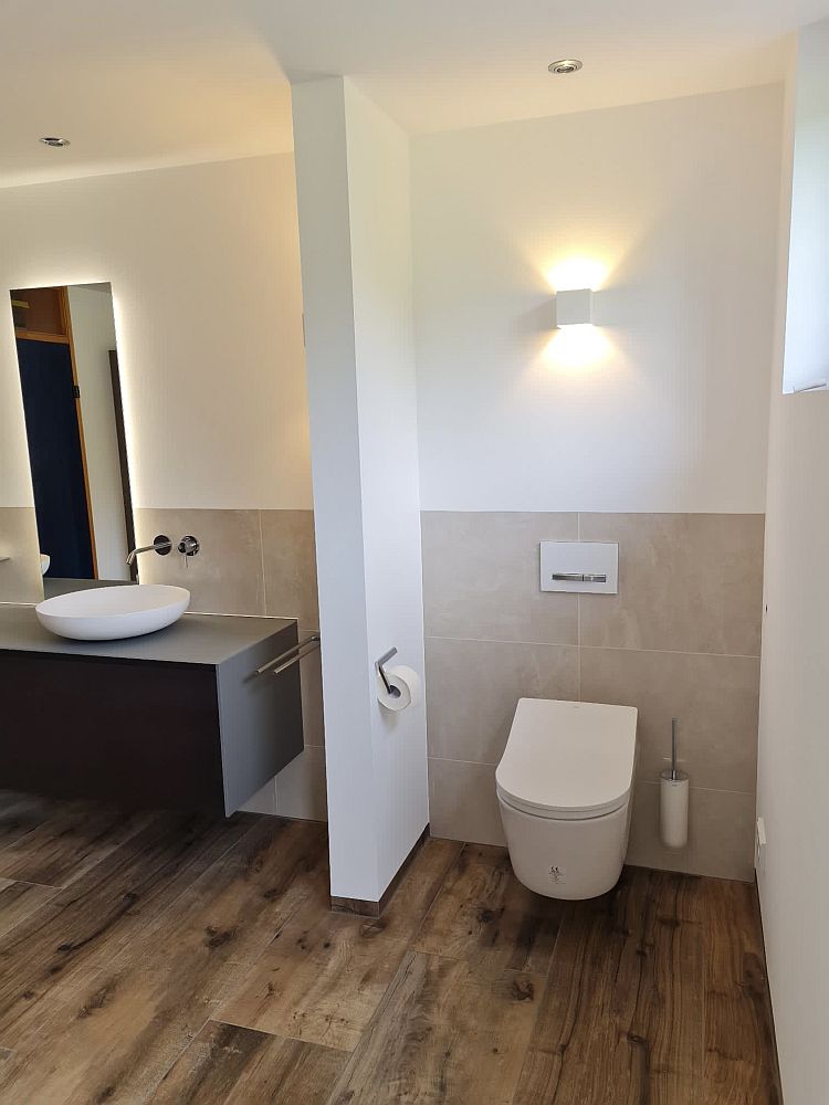 Wandhängendes WC mit Trennwand für Privatsphäre.