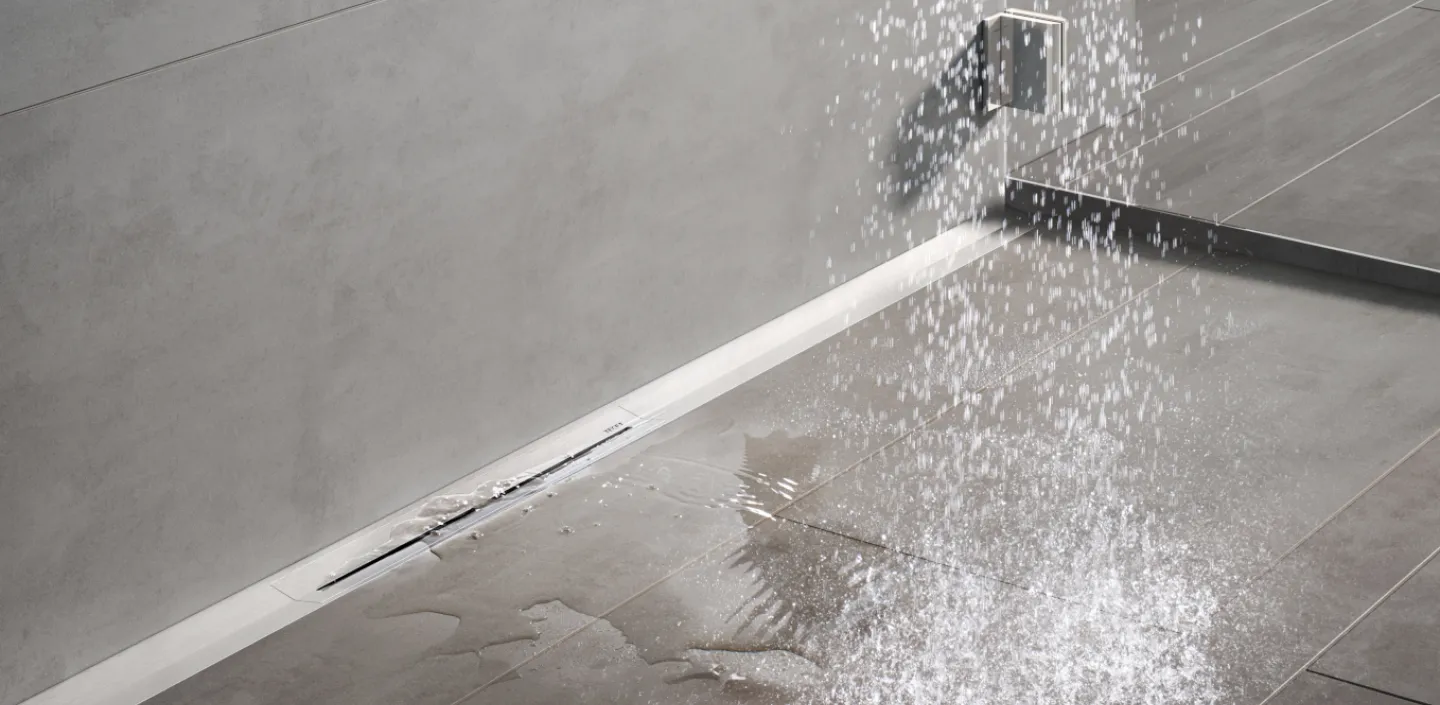 Die Ablaufrinne Drainline von TECE in einer bodenebenen Dusche mit Wasser.