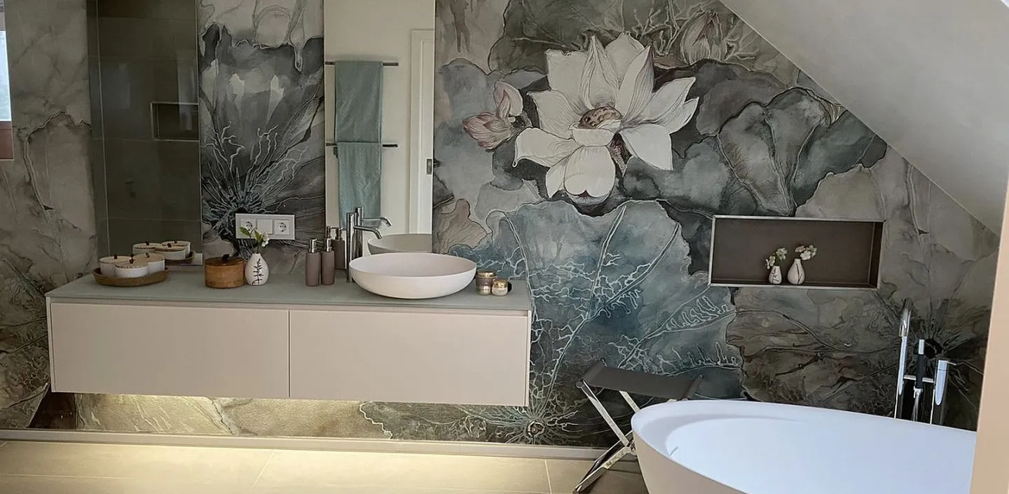 Ein elegantes Dachbadezimmer mit einer freistehenden weißen Badewanne und einem Waschtisch, der mit zwei runden Waschbecken und indirekter Beleuchtung gestaltet ist. 