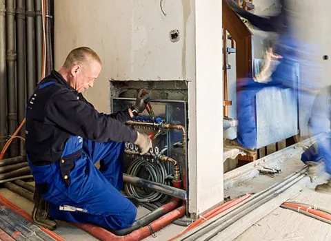 Anlagenmechaniker SHK bei der Verlegung einer Fußbodenheizung.