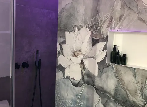 Eine elegante Duschwand mit floraler Wandgestaltung, mit dezenter LED-Beleuchtung.