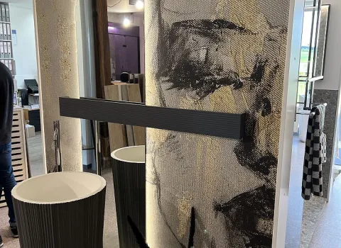 Ein stilvoller Standwaschtisch mit geriffeltem Design, beleuchtetem Wandspiegel und einer künstlerischen Wandverzierung.