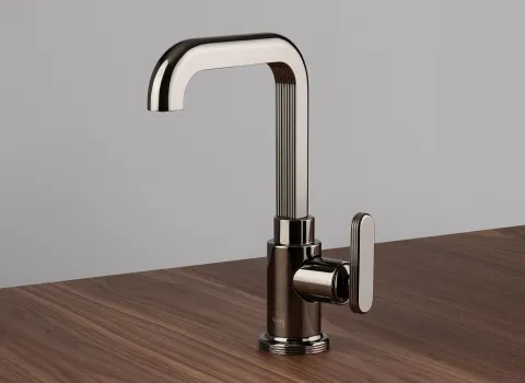 Ein einzelner Wasserhahn der Serie Frattini Parklane steht auf einer Holzoberfläche und besticht durch seine elegante Kombination aus glatten und gerillten Elementen.