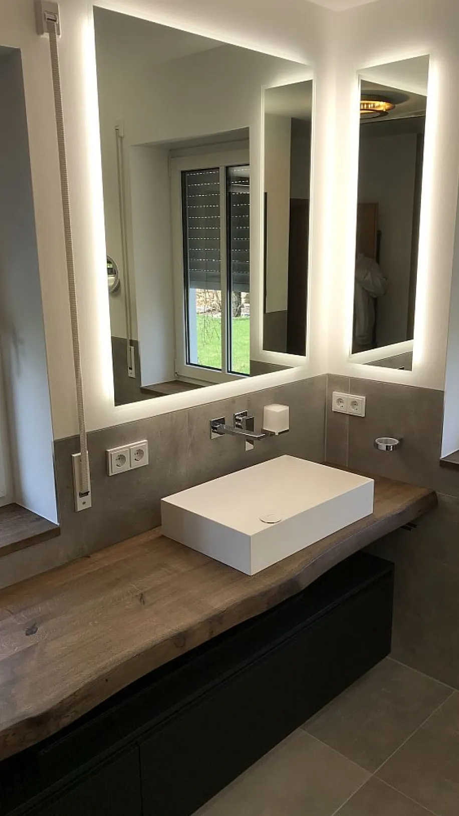 Helles Masterbad mit minimalistischem Design, einem eleganten Holz-Waschtisch, rechteckigem Waschbecken und Fenstern, die Tageslicht und Natur ins Bad bringen.