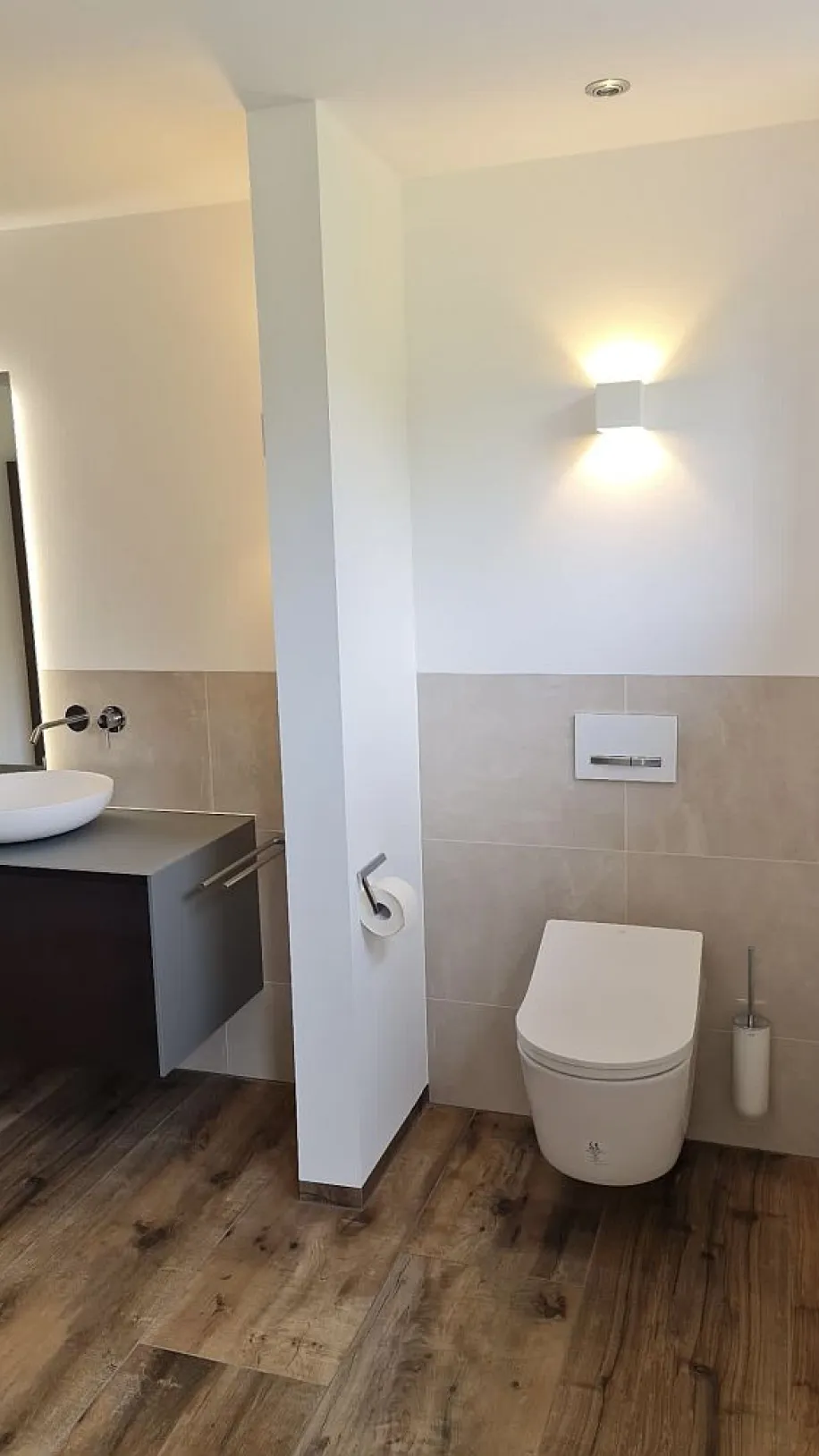Wandhängendes WC mit Trennwand für Privatsphäre.