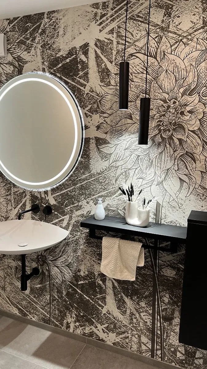 Waschplatz mit kreisrunden Lichtspiegel und Motivtapete.