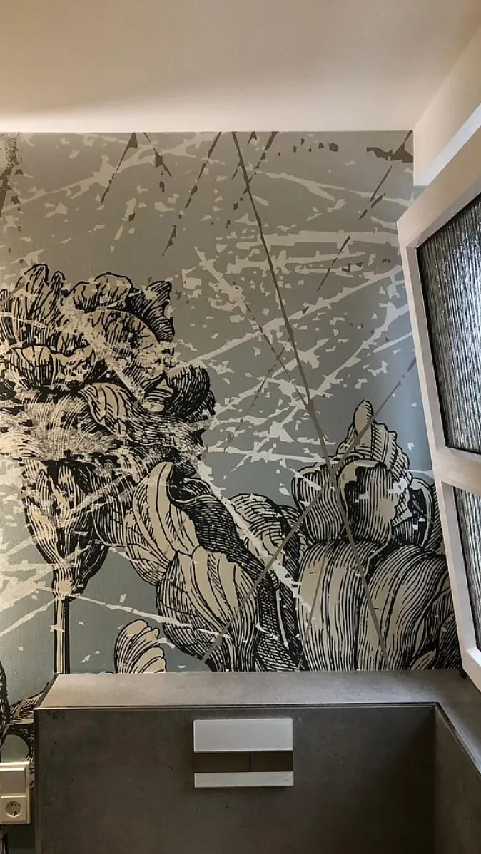 Ein elegantes Badezimmer mit einer auffälligen Wanddekoration, die großflächige Blumenmuster in monochromen Tönen zeigt.