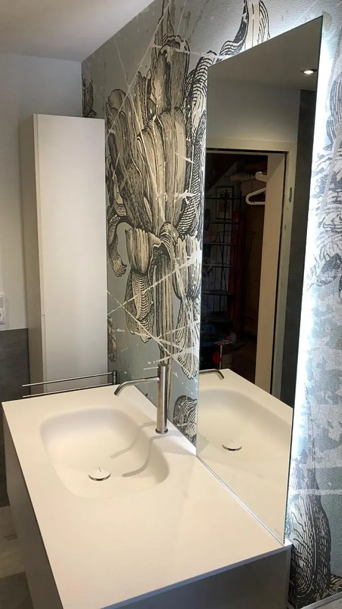 Der elegante Waschtisch ist mit einer schlichten Chromarmatur und einem rechteckigen Waschbecken ausgestattet.