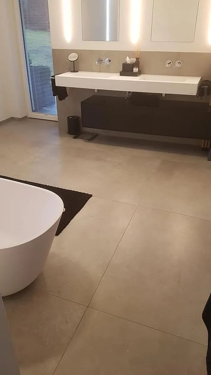 Geräumiges Badezimmer mit Doppelwaschtisch, LED-Spiegeln und freistehender Badewanne.