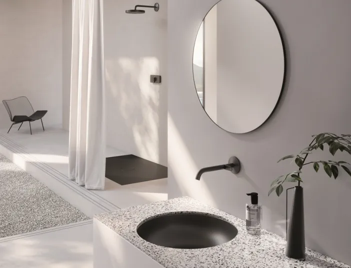 Einbauwaschtisch BetteBalance in Schwarz eingelassen in Natursteinplatte mit der passenden Dusche im Hintergrund